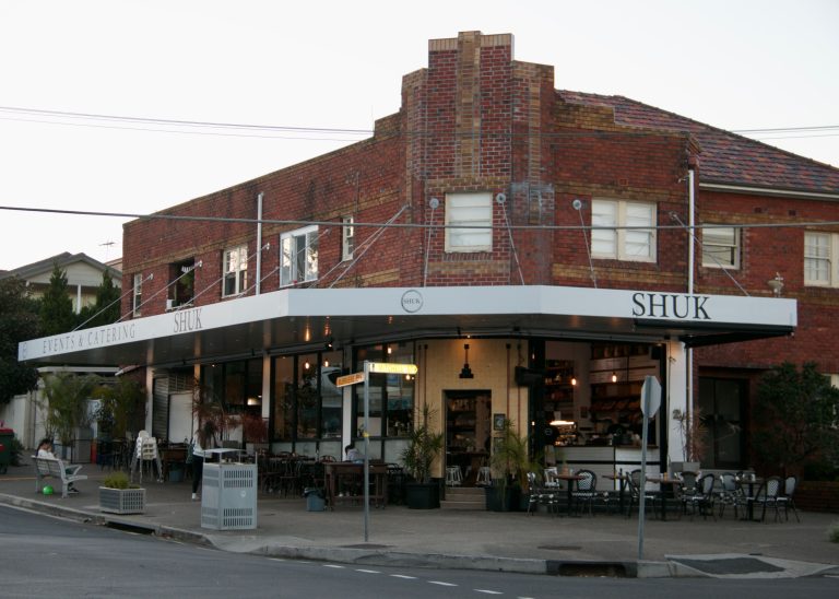 White wraparound shop front awning with lighting at Shuk restaurant, North Bondi