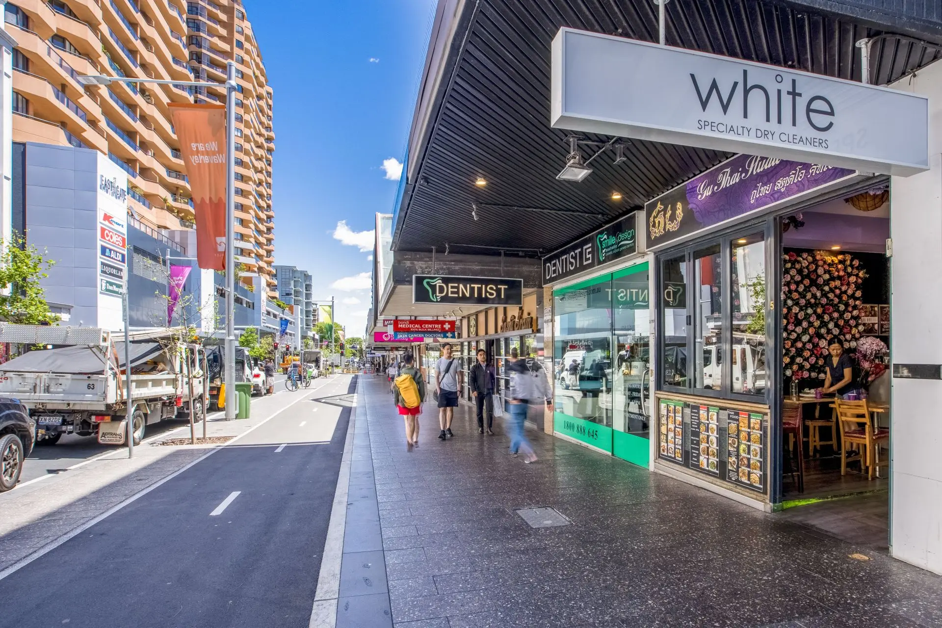 Slatted metal awning over a row of shopfronts and pedestrian footpath in Bondi Junction