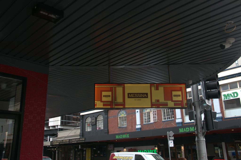 Underside of a slatted metal awning with illuminated signage, Parramatta street view