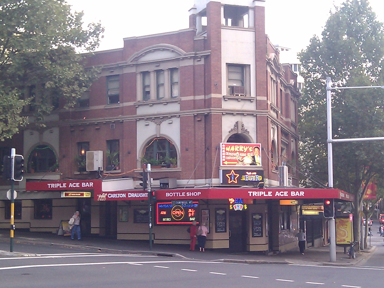 Heritage corner building with red fabric awnings over a bar shopfront in Surry Hills, Sydney