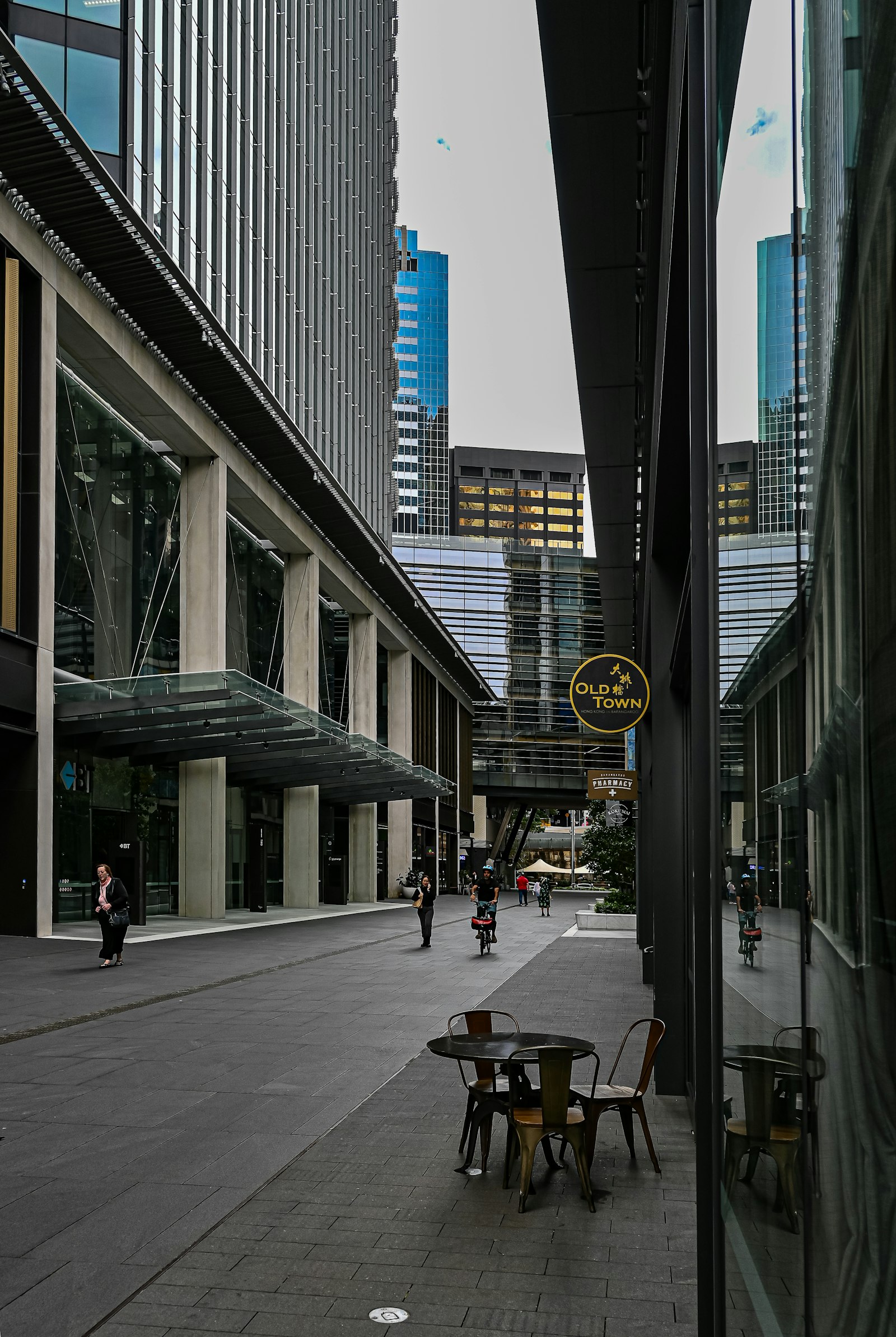 Outdoor café seating on a quiet Barangaroo street in the Sydney CBD, with modern building canopies overhead