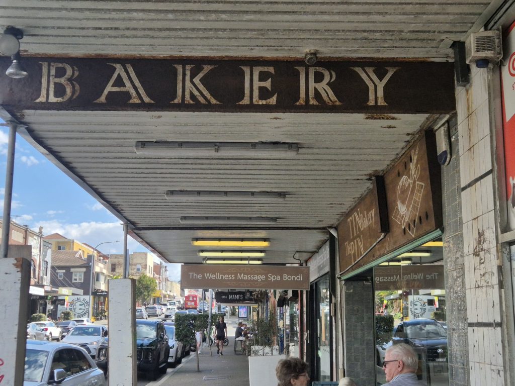 Old bakery shop awning with worn fascia and soffit on Bondi Road