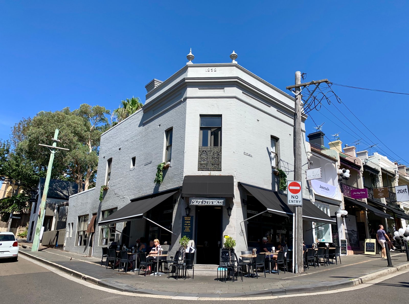 Heritage corner building at Five Ways, Paddington, with fabric awnings shading a footpath cafe