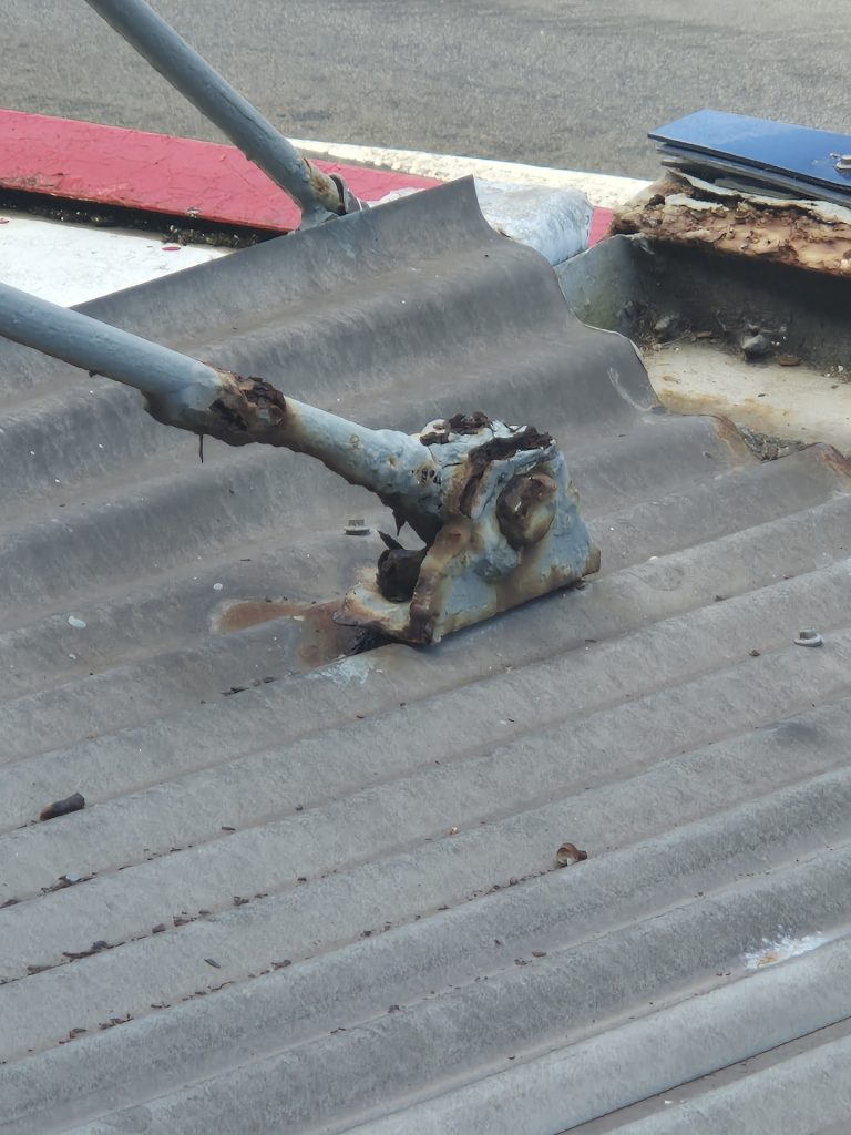 Rusted tie rod fixing on an older shop awning