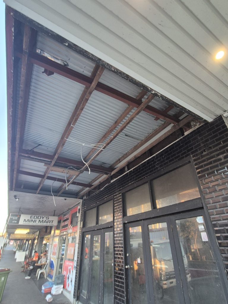 Awning soffit lining stripped back to the steel frame during repairs on Bondi Road